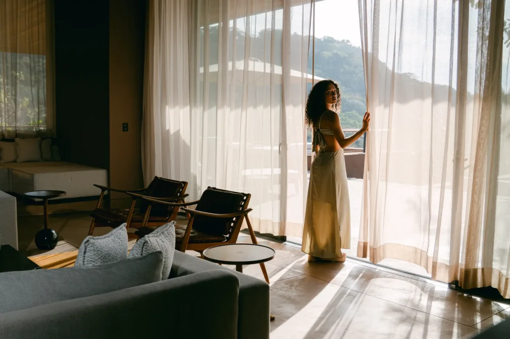 Rosewood Mandarina - Mujer en habitación de lujo con vista al mar